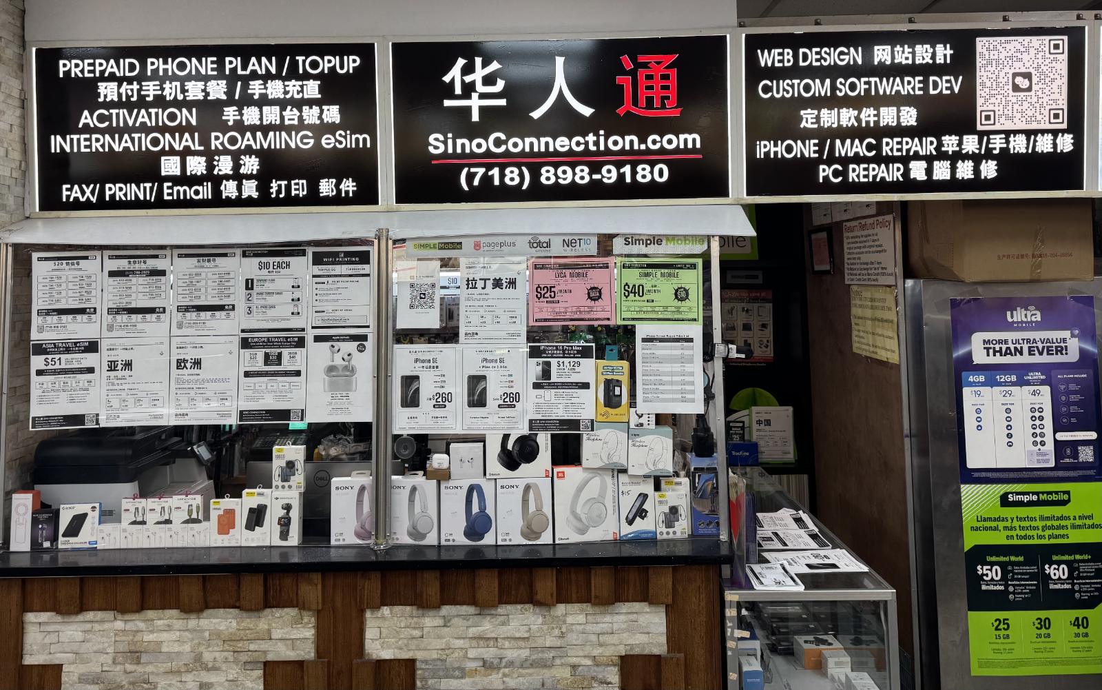正面看到的櫃檯,上方燈箱招牌寫著:預付手機方案、開台、國際漫遊 eSIM、傳真列印、網站設計、蘋果與電腦維修