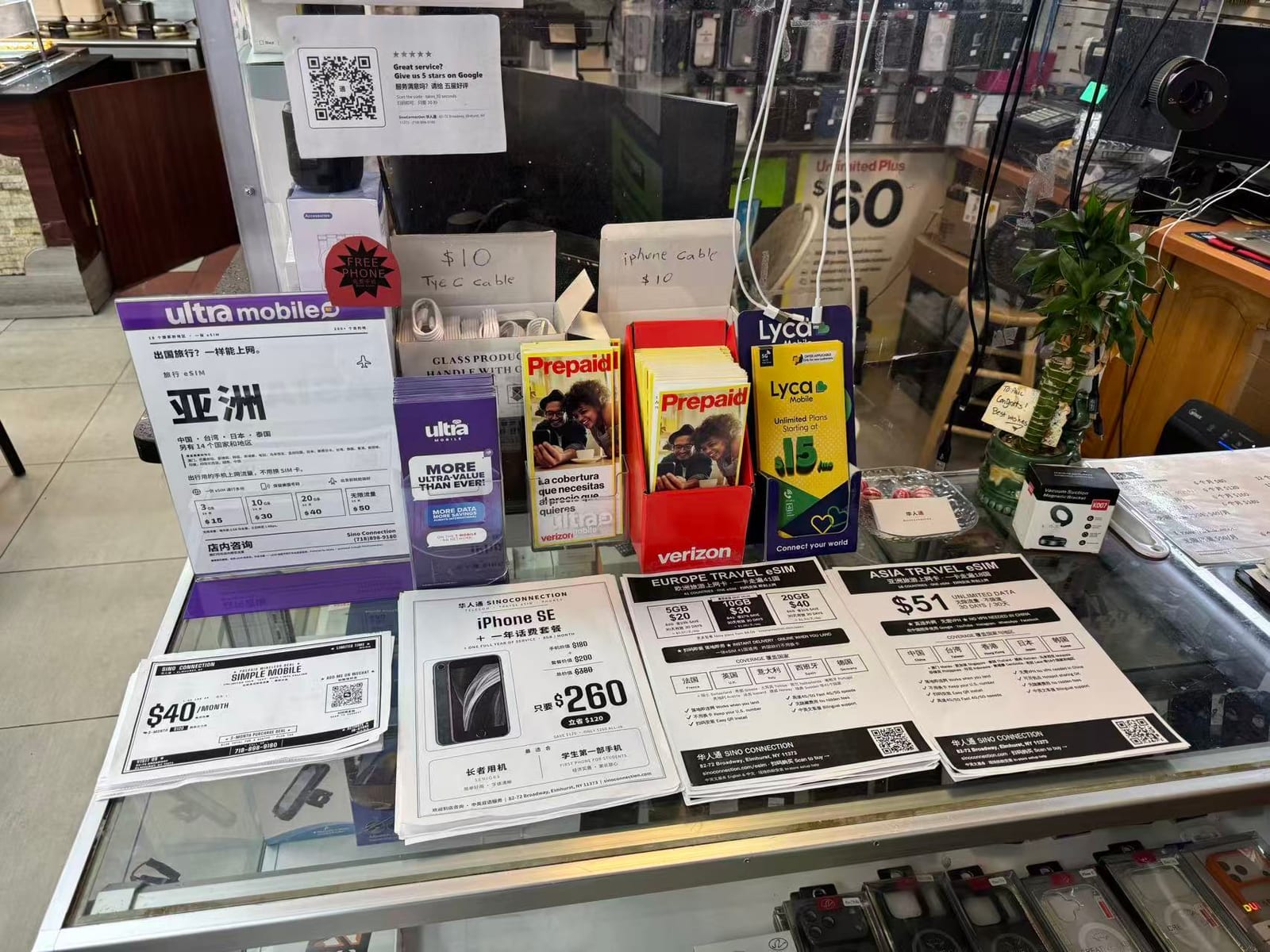 櫃檯上的亞洲、歐洲旅行 eSIM 單張,旁邊是各家電信的宣傳冊